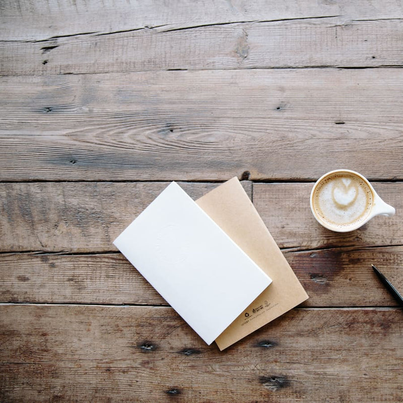 Coffee and a notebook on a timber bench